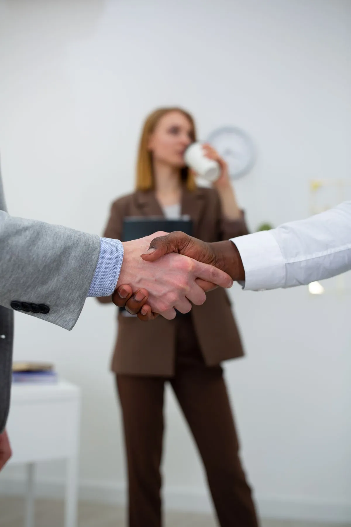 Apretón de manos entre dos profesionales en oficina